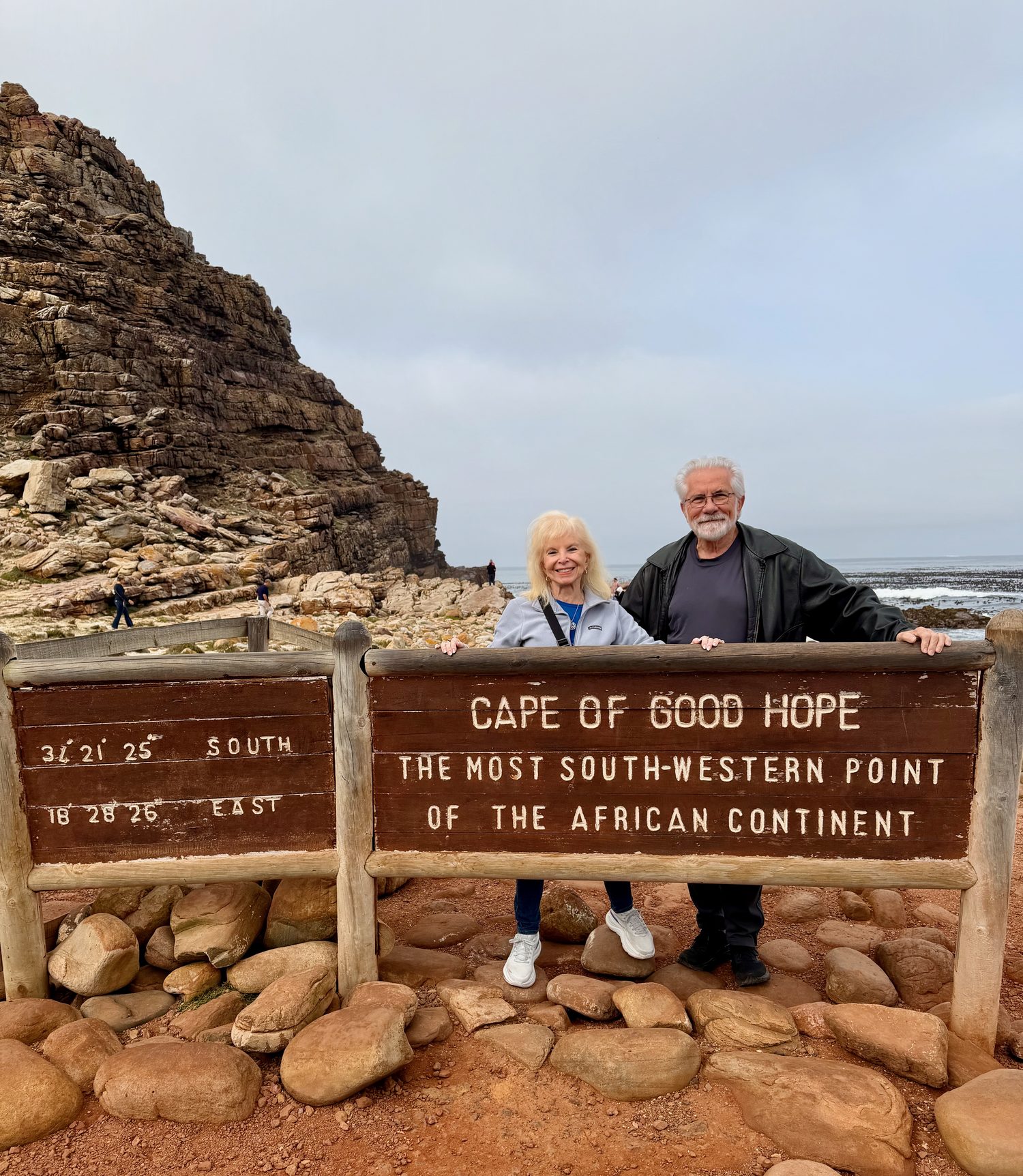Dana Wallace Cash and her husband beside the Cape of Good Hope sign on the rocky headland