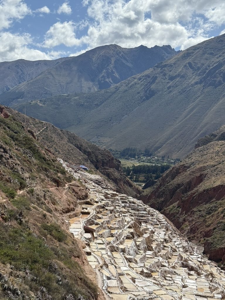 Thousands of shallow white salt-evaporation ponds stepped down a ravine at Maras