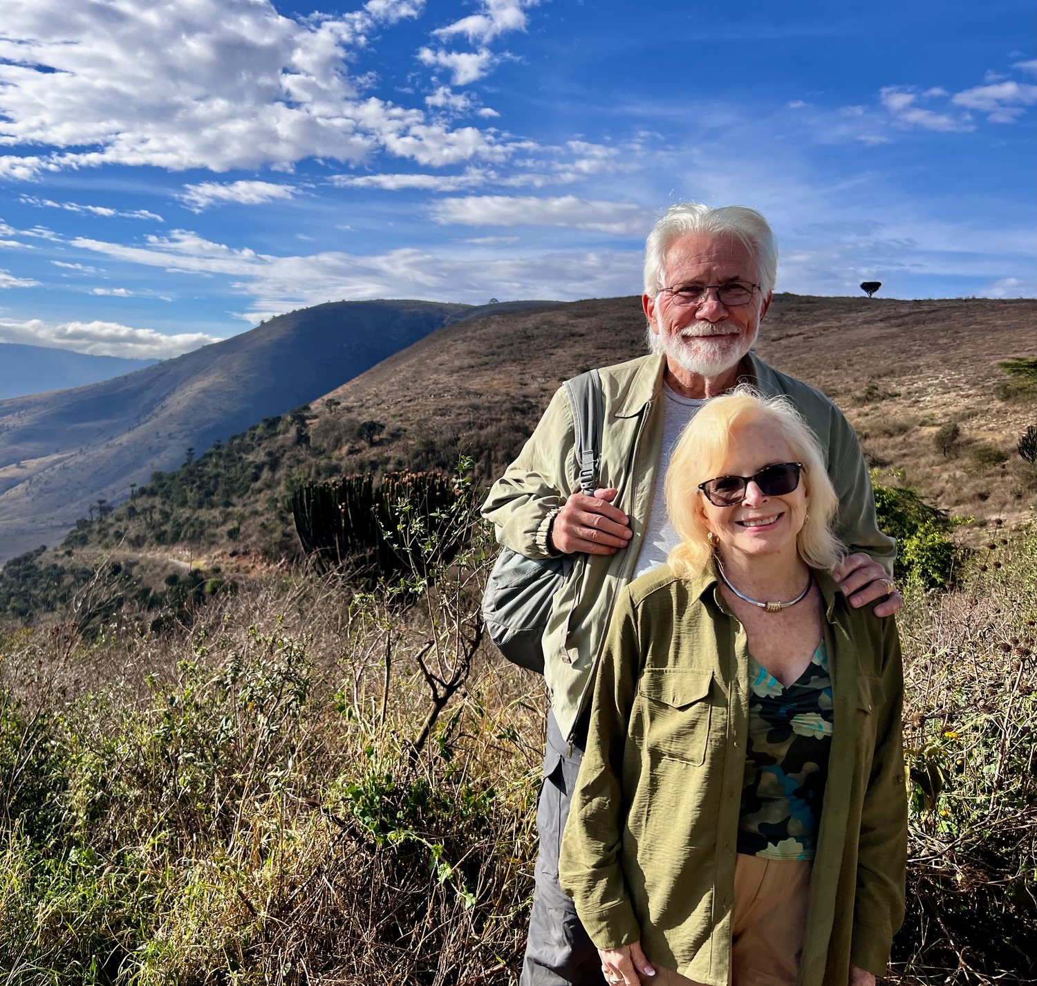 Dana Wallace Cash and her husband standing on the crater rim with the crater stretching behind them